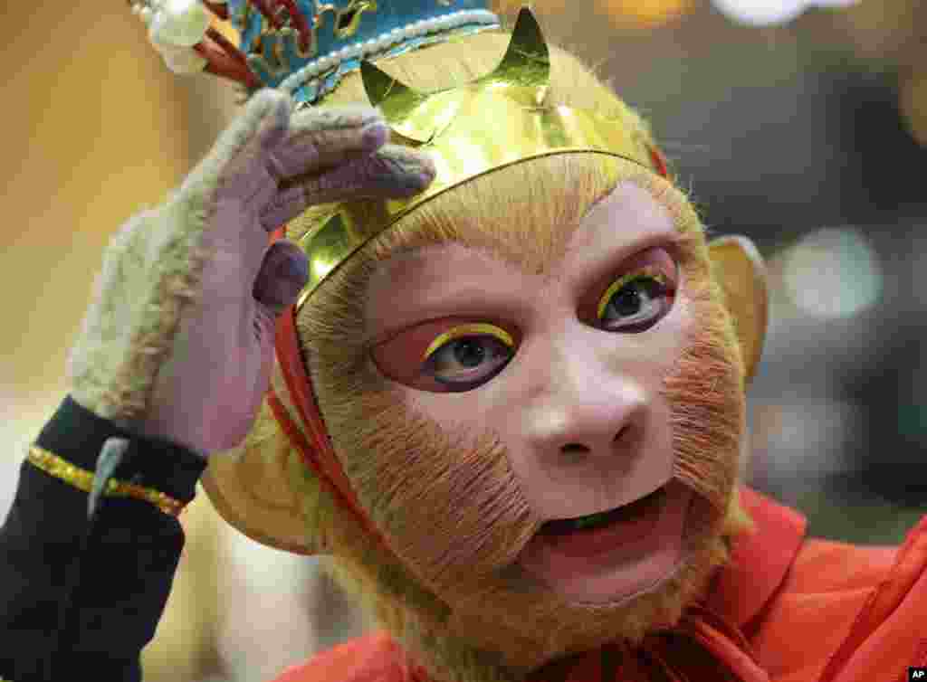 A Chinese man, dressed as the legendary Monkey God of Chinese folklore adjusts his mask and prepares before a show at Seacon Square in Bangkok, Thailand.