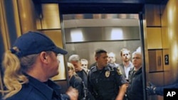 Escorted by law enforcement officers, Wisconsin Assembly Republicans exit the state Capitol after cutting off debate and rapidly voting to pass a controversial budget repair bill, February 25, 2011