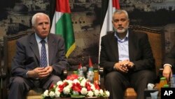 FILE - Gaza's Hamas Prime Minister Ismail Haniyeh, right, and senior Fatah official Azzam al-Ahmad meet in Gaza for talks aimed at reaching a reconciliation agreement between the two rival Palestinian groups, Hamas and Fatah on April 22, 2014.