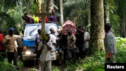 Des parents et amis portent le corps d'Yvonne Masika tuée lors d'une attaque perpétrée par des présumés rebelles de l'ADF-NALU, ils se dirigent au lieu de l'enterrement dans un village près de Beni Mbau, dans la province du Nord-Kivu, en RDC, le 21 octobre 2014.