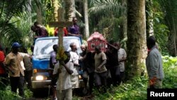 FILE - Relatives and friends carry the body of Yvonne Masika, who was killed during an attack by suspected ADF-NALU rebels, for burial in Mbau village near Beni, in North Kivu province, D.R.C., Oct. 21, 2014.