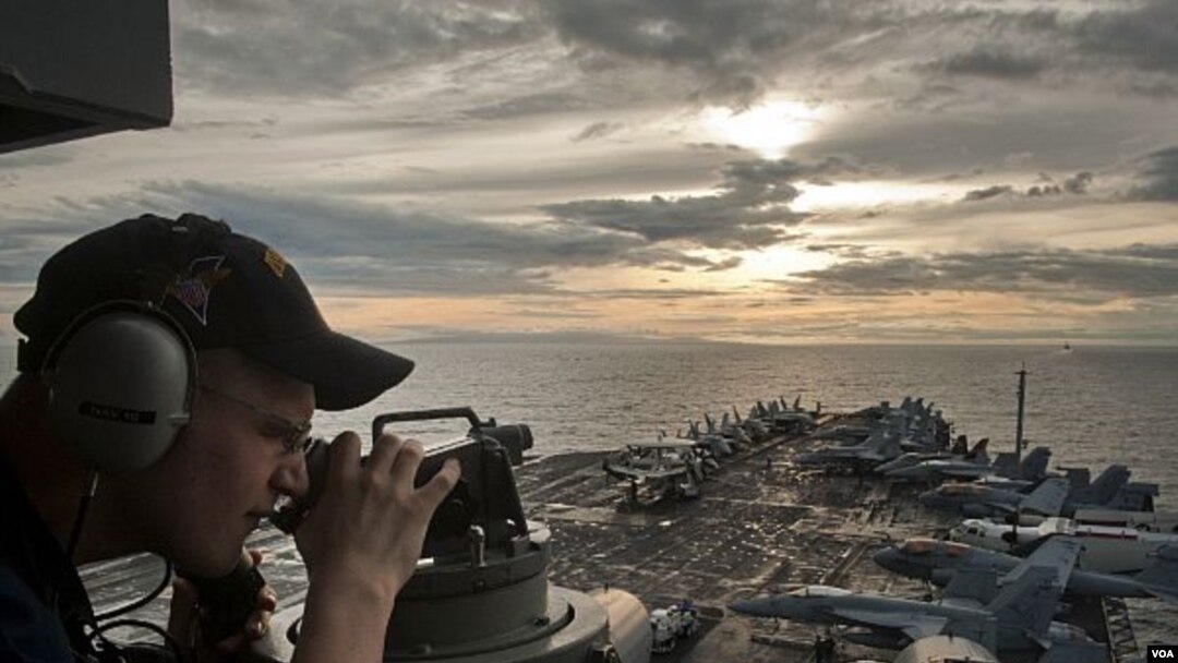 Seorang petugas pengawas pantai, Jacob Williams, menggunakan teleskop untuk mengamati kapal induk USS Carl Vinson (CVN 70) dan Carrier Strike Group (CSG) 1 mendekati Surigao Strait, FIlipina (Foto: dok).