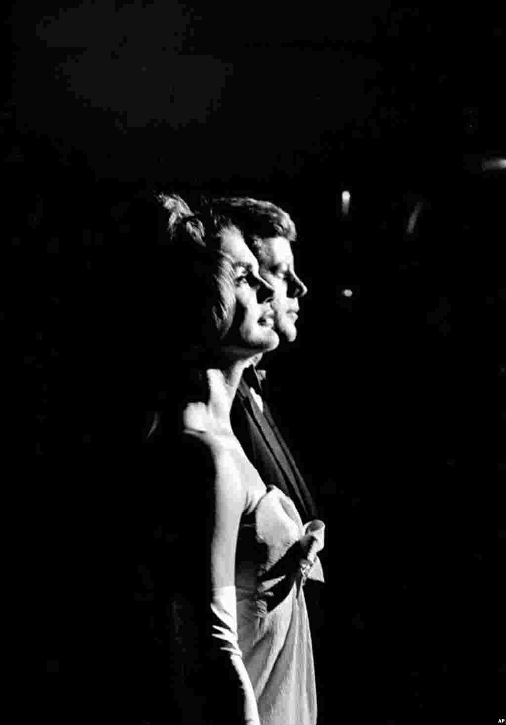 First lady Jacqueline Kennedy and President John F. Kennedy stand at attention during the playing of the national anthem at start of a reception during their state visit to Mexico City, Mexico, on June 30, 1962. (AP Photo/Henry Burroughs)