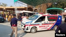 A police officer guides an ambulance after a suicide blast in a mosque, at police line area in Peshawar, Pakistan Jan. 30, 2023.