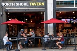 FILE - People gather at the North Shore Tavern in Pittsburgh, June 28, 2020.