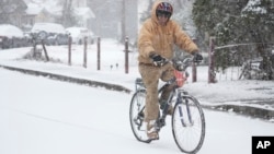 Jesse Thompson anda en bicicleta en la nieve, el 10 de enero de 2025, en Nashville, Tennessee.