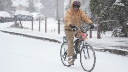 Jesse Thompson anda en bicicleta en la nieve, el 10 de enero de 2025, en Nashville, Tennessee.