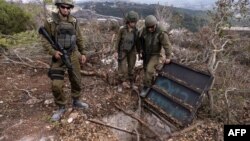 In a photo edited under Israeli military supervision, Israeli soldiers show what they say is a Hezbollah attack tunnel on Oct. 13, 2024.