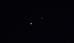 Jupiter (L) and Saturn (R) are seen during the 'Great Conjunction' where the two planets appear a tenth of a degree apart from one another, in this handout photo near Chapel Hill, North Carolina, Dec. 21, 2020.