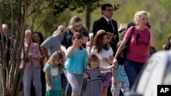 Mourners arrive at the Floresville Event Center to attend a funeral for members of the Holcombe family who were killed in the Sutherland Springs Baptist Church shooting, Nov. 15, 2017, in Floresville, Texas. 