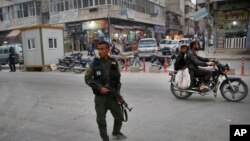 Seorang anggota pasukan keamanan internal Kurdi berpatroli di jalan raya kota Manbij, Suriah utara, Maret, 28, 2018. (Foto: dok). Dua personel koalisi dilaporkan tewas dan lima lainnya cedera akibat serangan bom pinggir jalan di kota ini, Kamis malam, (29/3).