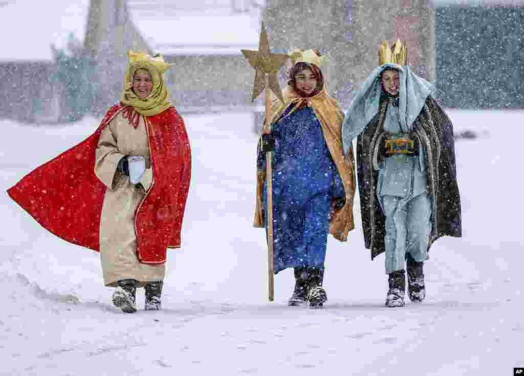 Miembros de un coro tradicional vestidos en el atuendo típico a través de la nieve en Eglingen, en el sur de Alemania, el sábado cinco de enero del 2019.&nbsp;