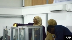 FILE - A Somali lawmaker casts her vote to elect a new president, inside Mogadishu airport, in Mogadishu, Somalia, Feb. 8, 2017.