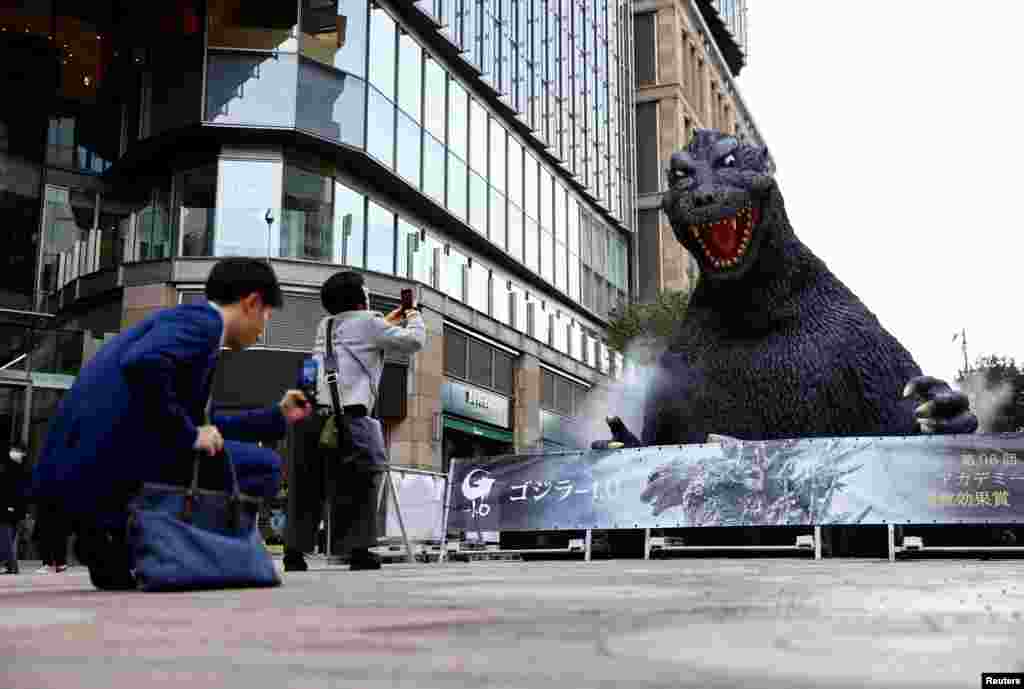 People take photos of a Godzilla statue which is installed to promote the film &#39;Godzilla Minus One&#39; in Tokyo,&nbsp;after the movie won the Oscar for Best Visual Effects at the 96th Academy Awards in Hollywood.