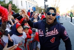 Washington Nationals manager Dave Martinez celebrates with fans during a parade to celebrate the team's World Series baseball championship over the Houston Astros, Nov. 2, 2019, in Washington.