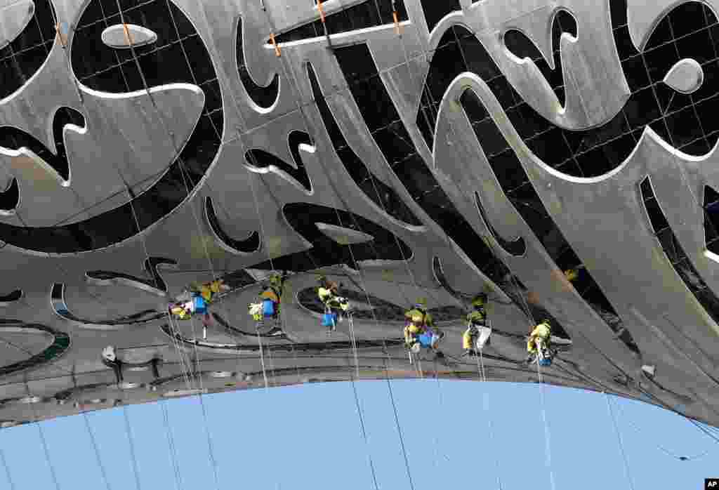 Laborers work on The Museum of the Future, a museum of innovation and design currently under construction in Dubai, United Arab Emirates.