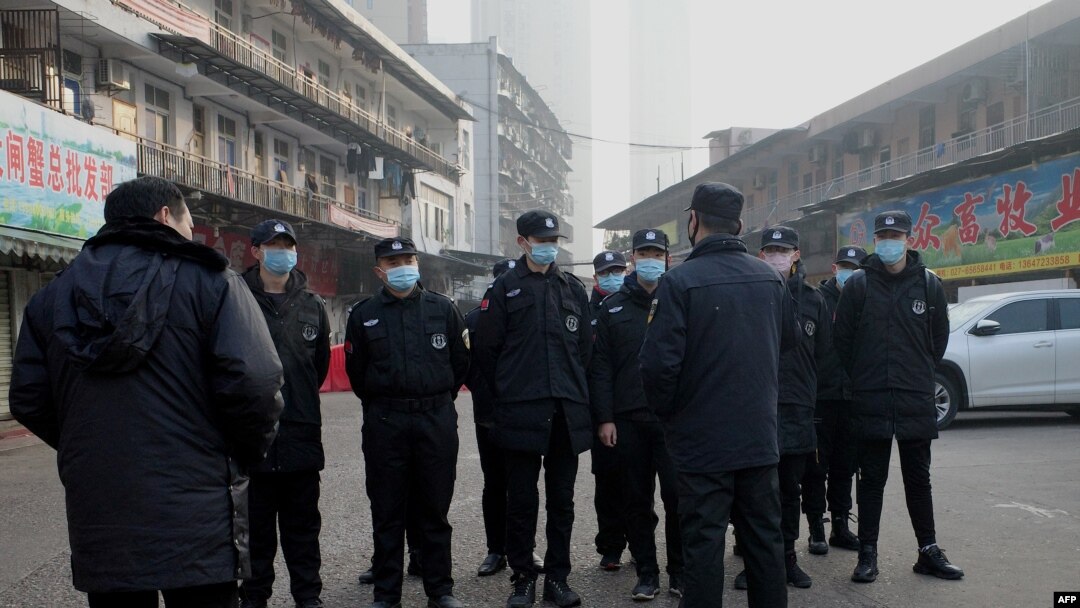 Security guards stand in front of the closed Huanan wholesale seafood market, where health authorities say a man who died from a respiratory illness, had purchased goods from, in the city of Wuhan, Hubei province, China, Jan. 12, 2020.
