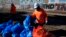 Workers bag cardboard and other discarded items at a Union Pacific railroad site on Jan. 20, 2022, in Los Angeles. 