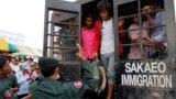 Cambodian migrant workers get off from a Thai truck upon their arrival from Thailand at Cambodia-Thai international border gate in Poipet, Cambodia, Tuesday, June 17, 2014. 