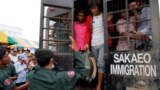 Cambodian migrant workers get off from a Thai truck upon their arrival from Thailand at Cambodia-Thai international border gate in Poipet, Cambodia, Tuesday, June 17, 2014.