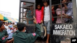 Cambodian migrant workers get off from a Thai truck upon their arrival from Thailand at Cambodia-Thai international border gate in Poipet, Cambodia, Tuesday, June 17, 2014. The number of Cambodians who have returned home from Thailand this month after a threatened crackdown on foreigners working illegally has topped 160,000, a Cambodian official said Monday.