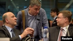 2016年5月24日欧洲经济与金融事务委员皮埃尔·莫斯科维奇（左）欧元区财长会议期间与希腊财政部长欧几里.德察卡洛托斯（中）和欧盟委员会副主席瓦尔迪斯·东布罗夫斯基斯交谈