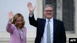 Italian Prime Minister Giorgia Meloni and British Prime Minister Keir Starmer wave as they walk in the garden of Villa Doria Pamphili after their meeting on Sept. 16, 2024 in Rome. 