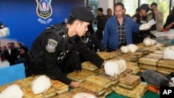 FILE - Thai policemen arrange packages of methamphetamine on a table before a press conference in Bangkok, Thailand, Feb. 15, 2013.