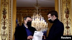 FILE - French President Emmanuel Macron meets historian Benjamin Stora for the delivery of a report on Algeria's colonization and war, at the Elysee Palace in Paris, France, Jan. 20, 2021. 