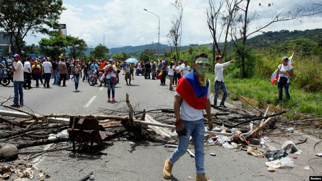 A demonstrator walks past a barricade during a rally demanding a referendum to remove Venezuela's President Nicolas Maduro in San Cristobal, Venezuela, Oct. 26, 2016.