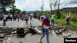 A demonstrator walks past a barricade during a rally demanding a referendum to remove Venezuela's President Nicolas Maduro in San Cristobal, Venezuela, Oct. 26, 2016.