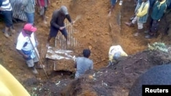 Locals dig for bodies after a house was covered by a landslide in the town of Mendi after an earthquake struck Papua New Guinea's southern highlands, Feb. 27, 2018, in this image obtained from social media. Francis Ambrose/via REUTERS