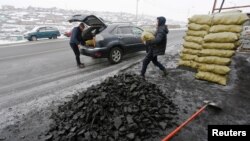 People load coal into a car in Ulaanbaatar, Mongolia as the wave of extreme cold hits the country, Dec. 22, 2016. 