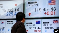 FILE - A man checks an electronic board for exchange rates in Tokyo, Japan, May 7, 2015. 