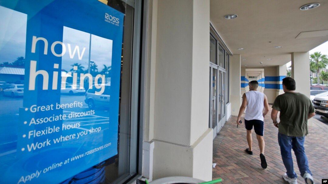 FILE - Shoppers walk past a now hiring sign at a Ross store in North Miami Beach, Florida, May 16, 2014.