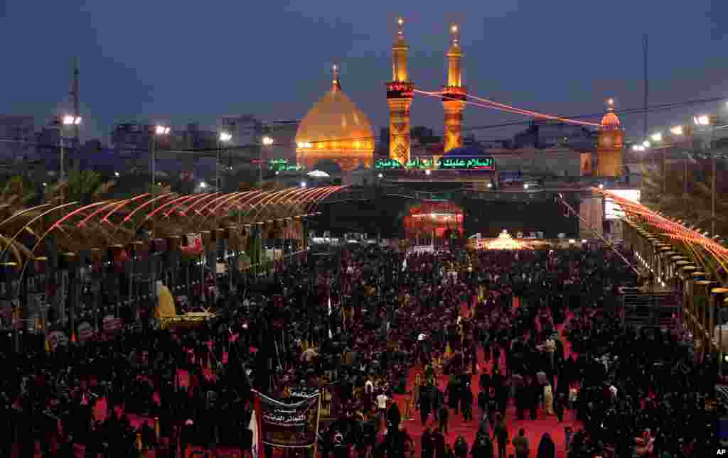 Shi'ite worshippers gather between the holy shrines of Imam Hussein and Imam Abbas, seen in the background, during Muharram in Karbala, Iraq, Nov. 12, 2013.