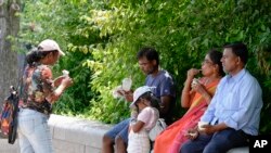 Una familia se refresca con helados en el National Mall, cerca de El Capitolio, el viernes 5 de julio de 2024, en Washington.