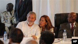 Former Brazilian President Luiz Inacio Lula da Silva, center left, speaks with a translator as he participates in a World Social Forum event with Senegalese President Abdoulaye Wade, right, at Place du Souvenir in Dakar, Senegal, Feb 7, 2011