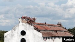 Narapidana memprotes di atas gedung penjara menuntut untuk mempercepat proses peradilan mereka dan bahwa mereka diberikan jaminan, setelah jumlah kasus Covid-19 meningkat di penjara di negara itu, di Kolombo, Sri Lanka 18 November (Foto: Reuters)