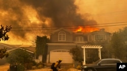 Una residencia es presa de las llamas mientras los bomberos combaten un incendio en el vecindario de Pacific Palisades, el martes 7 de enero de 2025, en Los Ángeles.