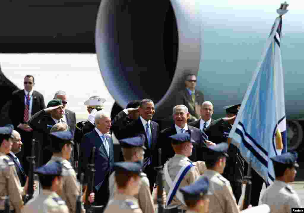 U.S. President Barack Obama smiles next to Israeli Prime Minister Benjamin Netanyahu and President Shimon Peres at Ben Gurion International Airport near Tel Aviv, March 20, 2013. 