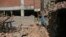 A Nepalese woman collects bricks from a destroyed building in Bhaktapur, Nepal, April 24, 2017. Nepal's government has been criticized for moving slowly in dispersing funds that would allow people to rebuild.