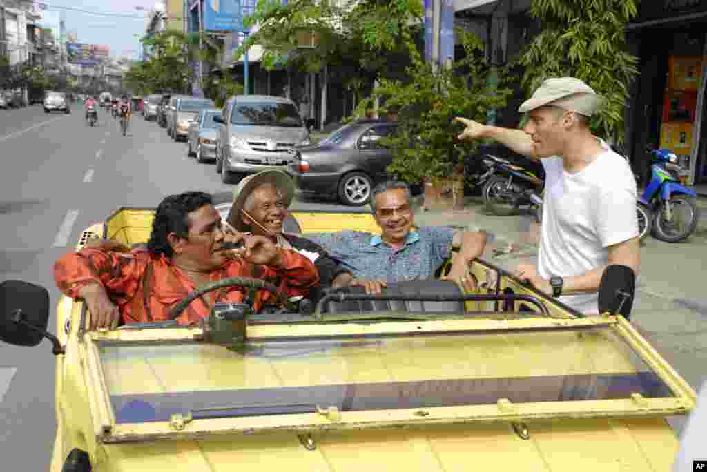 Sutradara &quot;The Act of Killing&quot; Joshua Oppenheimer (kanan) berbicara dengan tokoh utama filmnya, Anwar Congo (kedua dari kiri, memakai topi). Film ini meraih nominasi film dokumenter panjang terbaik. (AP/Drafthouse Films)