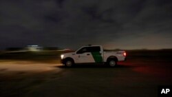 A U.S. Customs and Border Protection truck drives by a road adjacent to the U.S.-Mexico border, March 22, 2021, in Hidalgo, Texas. 