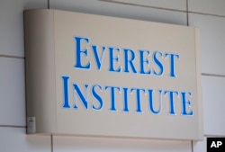 FILE - In this July 8, 2014 file photo, an Everest Institute sign is seen in an office building in Silver Spring, Md. (AP Photo/Jose Luis Magana, File)