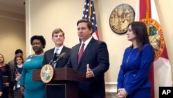 El gobernador de Florida Ron DeSantis habla en conferencia de prensa acompañado de la subsecretaria de Salud, doctora Shamarial Roberson (izq.), el director general de salud estatal doctor Scott Rivkees (2do. desde la izq.), y la vicegobernadora Jeanette Nuñez (der.).