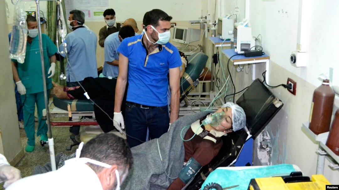 A woman affected by what activists say was a gas attack on the town of Telminnes breathes through an oxygen mask at Bab al-Hawa hospital, where she was transferred to, close to the Turkish border April 21, 2014. 