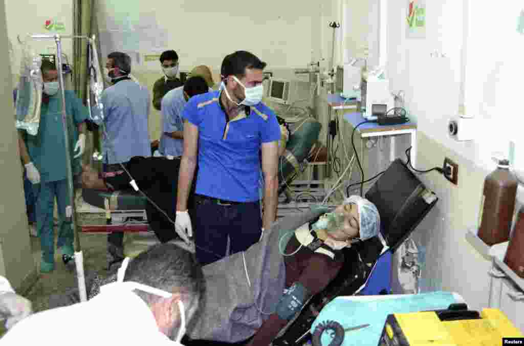زنی که هدف حمله بمب های گازی قرار گرفته، در بیمارستان باب الحوا در مرز ترکیه با کمک ماسک اکسیژن نفس می کشد - ۲۱ آوریل ۲۰۱۴
