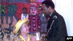 FILE - British Queen Elizabeth II looks up to Zulu King Zwelithini as he presents her a replica of a cup given to King Cetshwayo by Queen Victoria in 1882, here at a ceremonious luncheon in Durban, March 25, 1995.