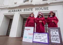 FILE - Bianca Cameron-Schwiesow, from left, Kari Crowe and Margeaux Hartline, dressed as handmaids, take part in a protest against HB314, the abortion ban bill, at the Alabama State House in Montgomery, Ala., April 17, 2019.